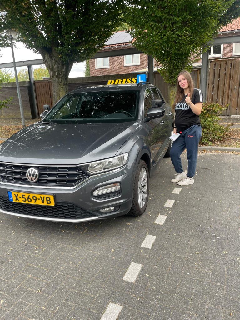 Geslaagde leerling bij de lesauto van Rijschool Driss